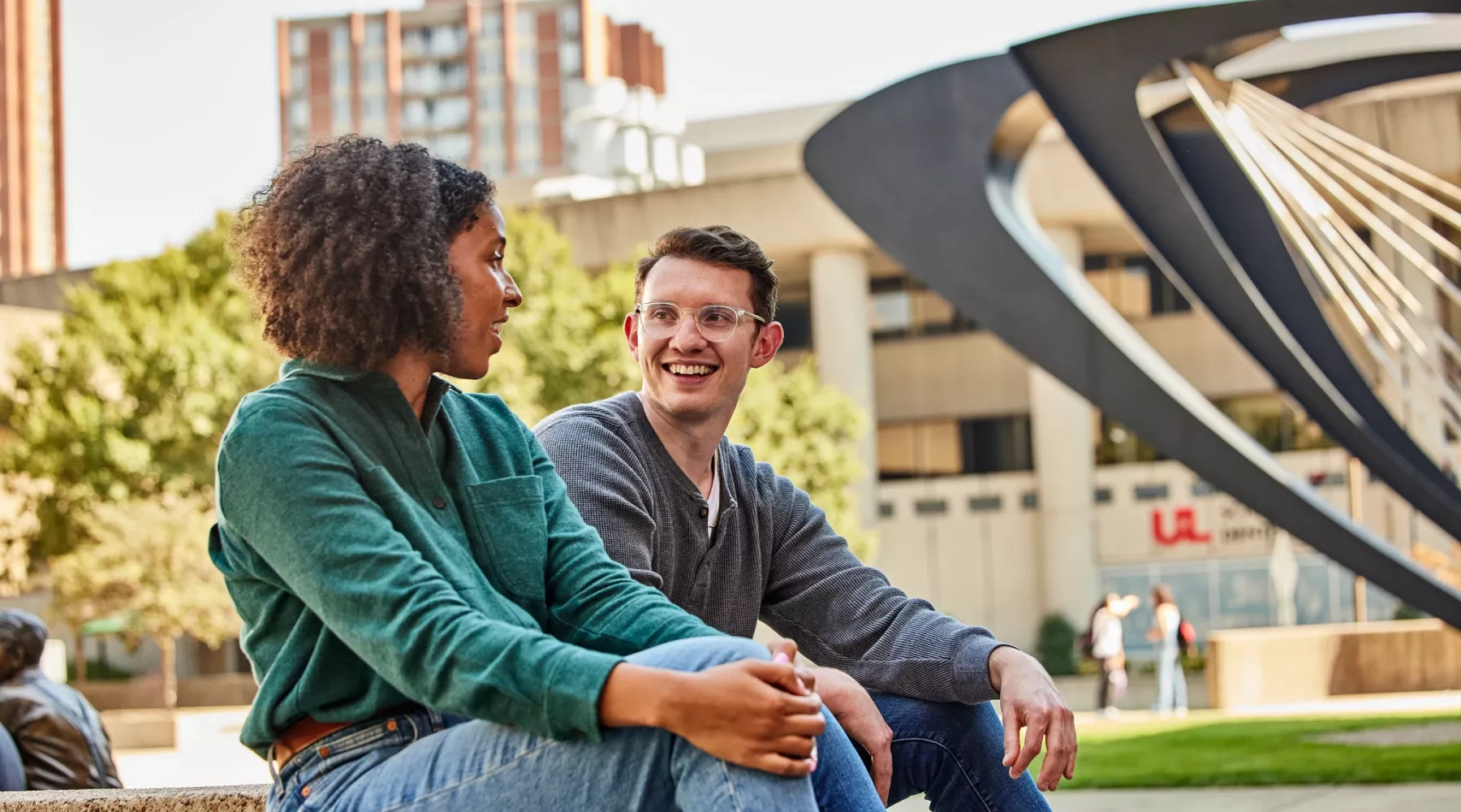 Two students have a pleasant conversation with each other in the HSC courtyard.