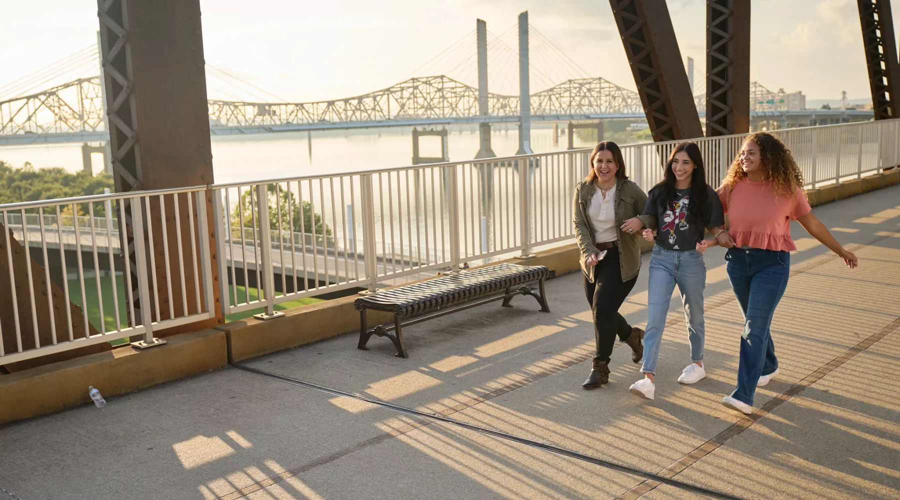 Three students walking and talking on the Big Four Bridge at Waterfront Park in downtown Louisville.