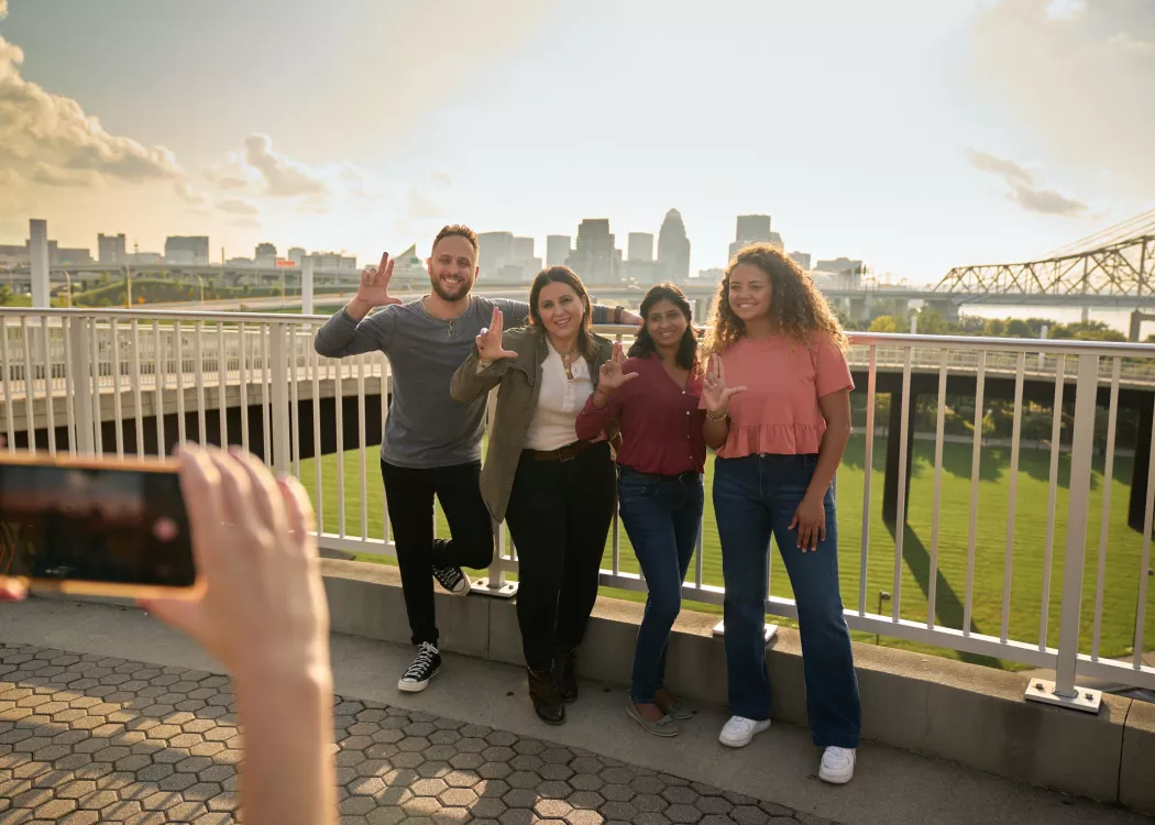 Students throwing up their L's for a group photo opportunity at the Big Four Bridge at Waterfront Park in downtown Louisville.