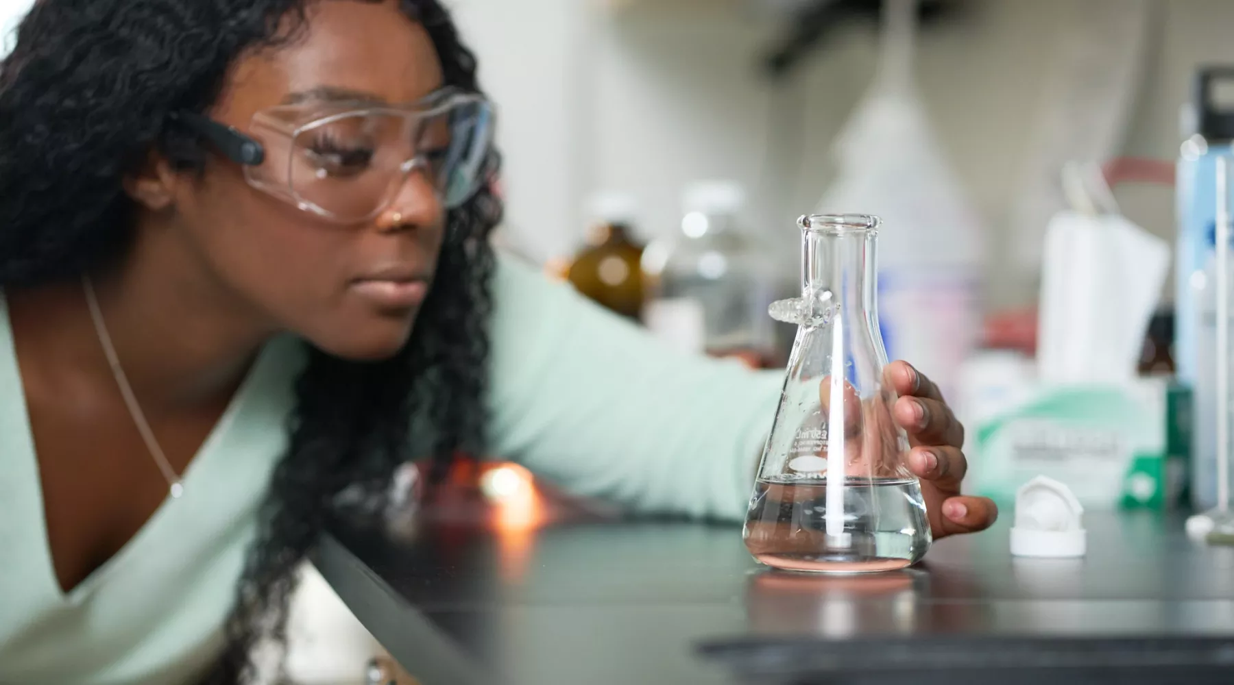 Female student performs chemistry experiment in a lab