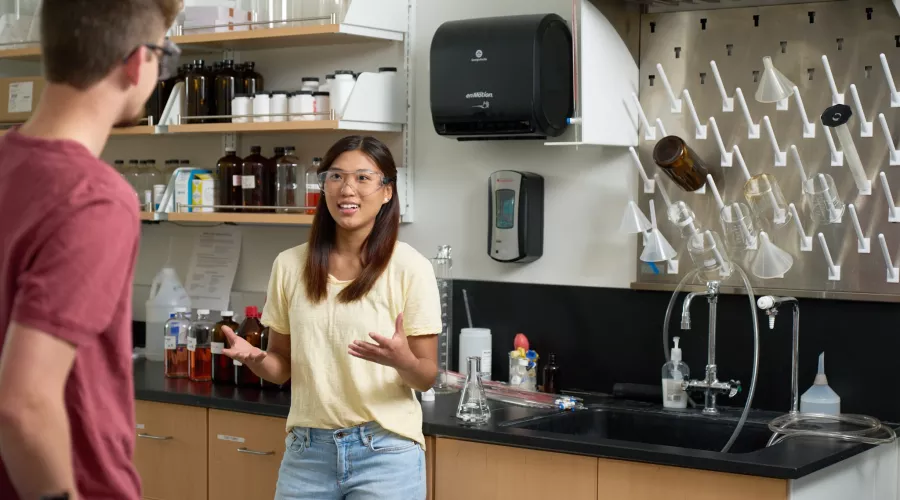 Two students having a discussion in a chemistry laboratory
