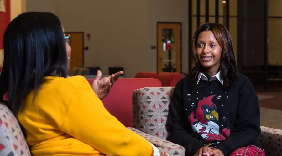 Two staff conversing while sitting in chairs in the SAC.
