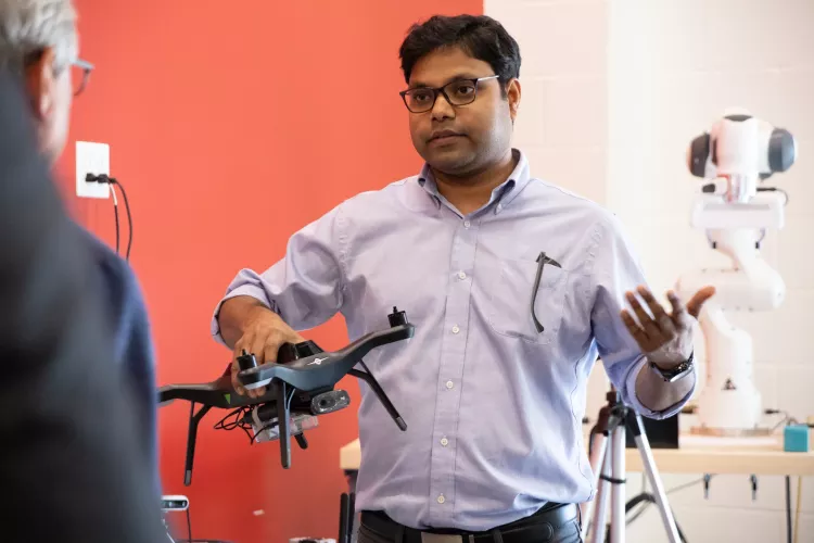 Dr. Sabur Baidya talking while holding a drone.