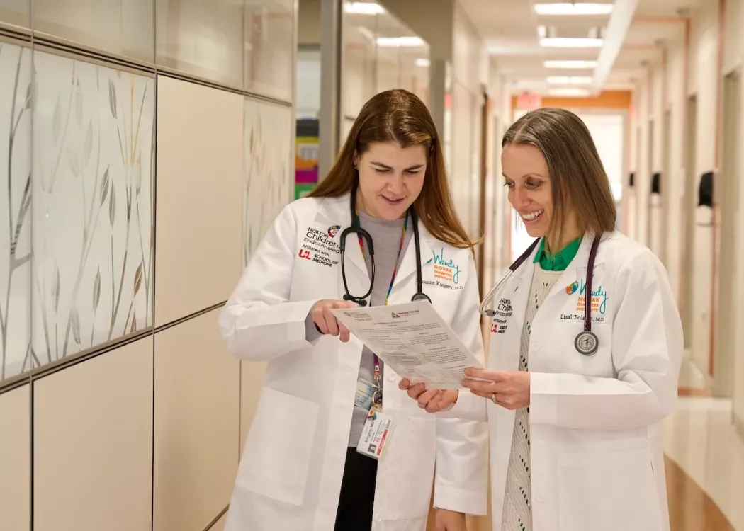Two pediatric doctors talking in the hallway of the doctor's office.