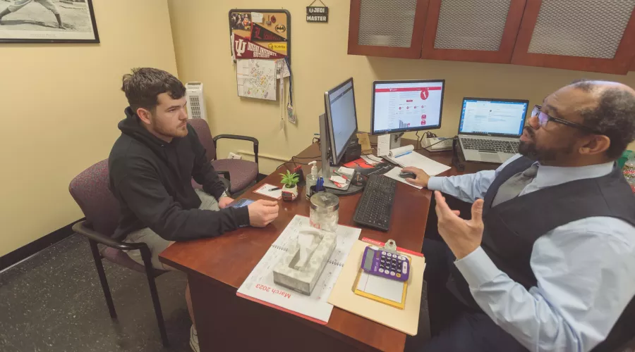 Metro College,Counselor Patrick,McKinney works,with a student.