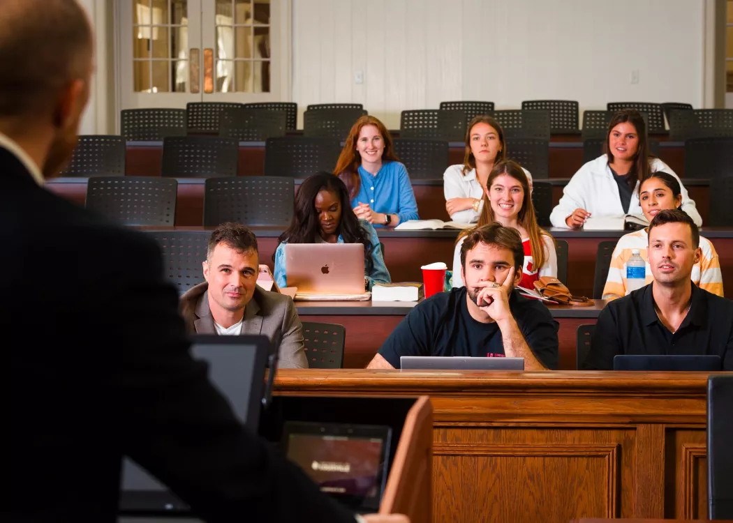 Students in a courtroom setting listening to a professor