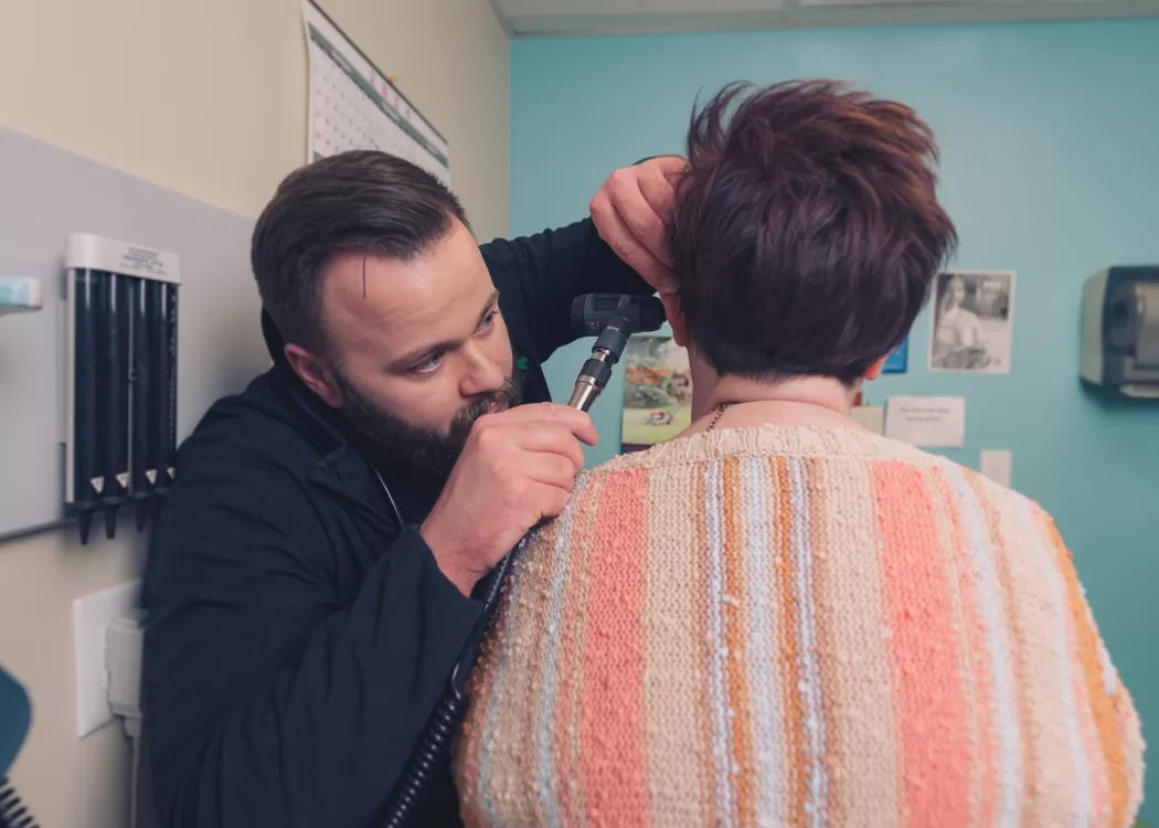 Jacob Hunter examines a patient at the Mountain Comprehensive Health Corp. center.