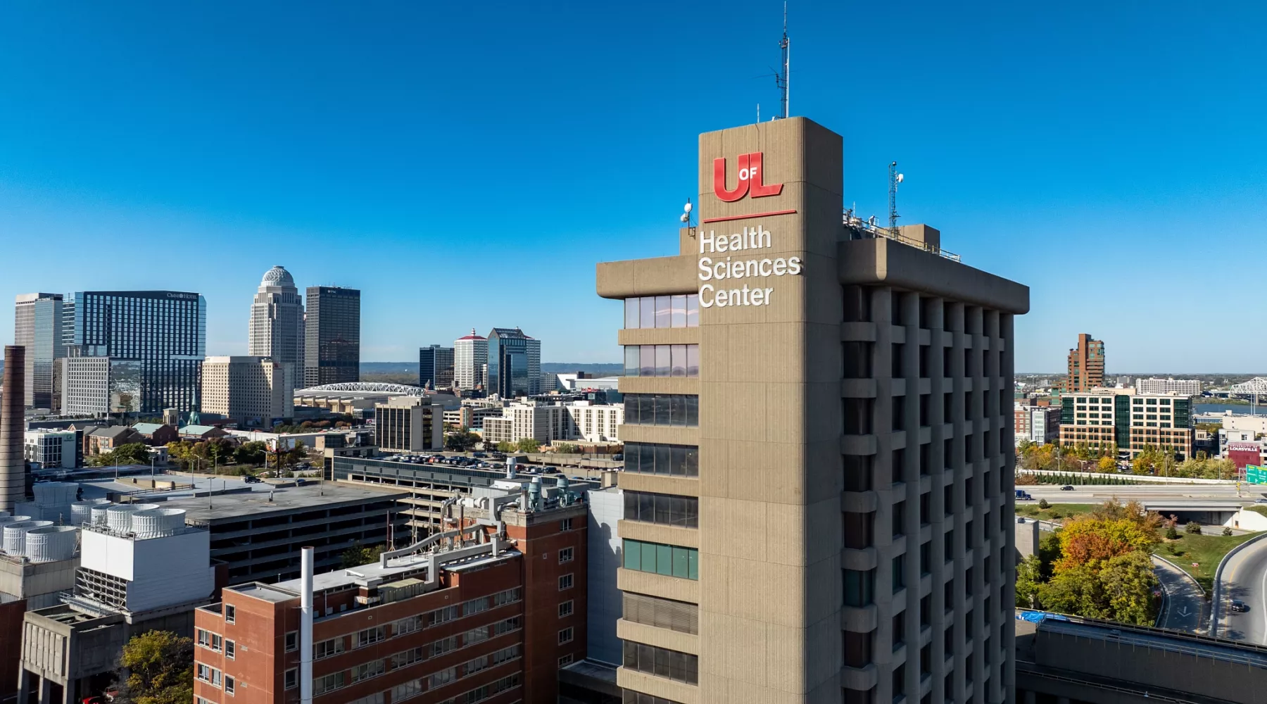 High angle shot of the Health Sciences Center tower with downtown Louisville